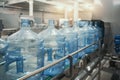 Plastic PET bottles or gallons on production line or conveyor belt in water factory for bottling pure drinking water