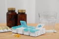 Plastic pill box and different medicaments on wooden table