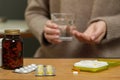 Plastic pill box with different medicaments on wooden table, space for text