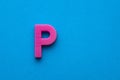 Alphabet letter P - Pink plastic piece on blue foamy background