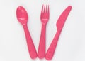 Pink spoon, fork, knife and plate on the white background Royalty Free Stock Photo