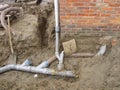 Plastic pipes in the ground next to a house