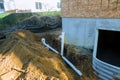 Plastic piping and a rainpipe against and around the a drainpipe in ground house