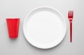 Plastic plate, forks and cup on white Royalty Free Stock Photo