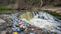 Plastic pollution chokes a small waterfall polluting the river and environment Royalty Free Stock Photo