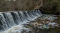 Plastic pollution chokes a waterfall highlighting environmental degradation Royalty Free Stock Photo