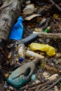 Plastic pollution muddy puddle with bottles waste and styrofoam on beach