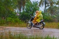 Plastic raincoats while riding a scooter in Cambodia