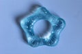 Plastic rattle toy for toddlers, toys for babies isolated on blue background. Soft material for children's teeth