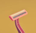 Plastic razor for depilation close-up on a yellow background