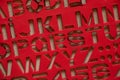 plastic red stencil with english letters as background Royalty Free Stock Photo