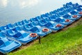 Plastic rental pedal boats parked on the lake shore on a sunny day. Active rest outdoors. Nobody Royalty Free Stock Photo