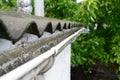 Plastic roof guttering, rain guttering & drainage with old asbestos roof.