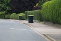 A plastic rubbish bins stand in a row on the side of the road Royalty Free Stock Photo