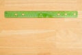 Plastic ruler on a wood desk background