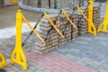 Plastic safety barrier protects road work area. Yellow-black plastic fence near street repair site. Outdoor construction work, Royalty Free Stock Photo