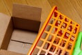 Plastic shopping basket on the floor and an open cardboard box Royalty Free Stock Photo