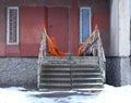 Plastic snow shovels are stacked on the concrete porch of the house