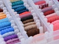 Plastic sorting box full of bobbins with different color embroidery threads. Royalty Free Stock Photo