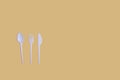 Plastic spoon, fork and knife on yellow background flat lay. Horizontal image Royalty Free Stock Photo