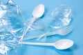 Plastic spoons, forks and cups as a disposable waste with copy space on bright blue background. Environmental pollution and litter Royalty Free Stock Photo