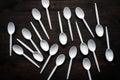 Plastic spoons scattered on wooden table Royalty Free Stock Photo