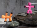 Plastic stick figures posed on wet rocks.