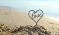 Plastic stick in shape of heart and word Love in sand on beach seashore