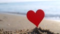 Plastic stick shape red heart sand sandy beach sea shore background of sea waves