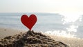 Plastic stick shape red heart sand sandy beach sea shore background of sea waves