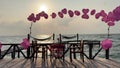 Plastic stick in shape of red heart in sand on sandy beach of sea shore on background of sea waves on sunny summer day