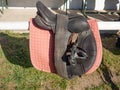 Plastic stirrups and leather strips on a dark saddle