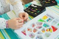 plastic substrates with multi-colored beads and the hands of a girl making a bracelet. handmade Royalty Free Stock Photo