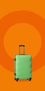 Plastic suitcase with wheels. Green plastic luggage suitcase isolated on orange background. Impressions of new places Royalty Free Stock Photo