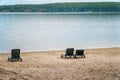 Plastic sun beds on an empty sandy beach on river Bank Royalty Free Stock Photo