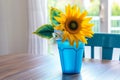 plastic sunflower centerpiece in a blue plastic vase on dining table Royalty Free Stock Photo