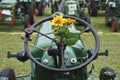 Plastic sunflower on the steering wheel of an old tractor Royalty Free Stock Photo