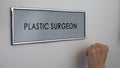 Plastic surgeon room door, hand knocking closeup, beauty procedure, rhinoplasty