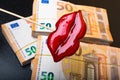 view of woman red lips on euro banknote, isolated on black, lips plastic surgery