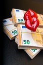 Cropped view of woman red lips on euro banknote, isolated on black, lips plastic surgery