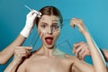 Plastic surgery or face lifting for young woman. Doctor's hands wearing gloves drawing lines, holding head of female Royalty Free Stock Photo
