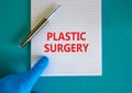 Plastic surgery symbol. White note with words Plastic surgery, beautiful blue background, doctor hand in blu glove and metallic Royalty Free Stock Photo