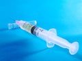 Plastic syringe on blue