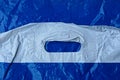 Plastic texture of a piece of crumpled blue white cellophane bag with handles