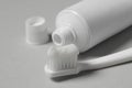 Plastic toothbrush with paste and tube on grey background, closeup Royalty Free Stock Photo