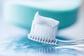 Plastic toothbrush with white toothpaste on a blue table Royalty Free Stock Photo