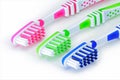 Green, blue and pink toothbrushes are isolated on a white Royalty Free Stock Photo