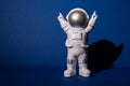 Plastic toy astronaut on colorful blue background Copy space. Concept of out of earth travel, private spaceman