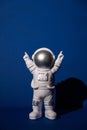 Plastic toy astronaut on colorful blue background Copy space. Concept of out of earth travel, private spaceman