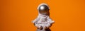 Plastic toy astronaut on colorful orange background Copy space. Concept of out of earth travel, private spaceman